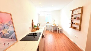 A kitchen with a wooden countertop, a sink, and a window. There is a shelf with kitchen items and a framed picture on the wall. - Centrally located apartment in Garmisch with parking space (Garmisch-Partenkirchen)