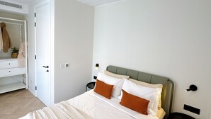Ein Schlafzimmer mit Bett, Nachttisch, Kleiderschrank und Spiegel.