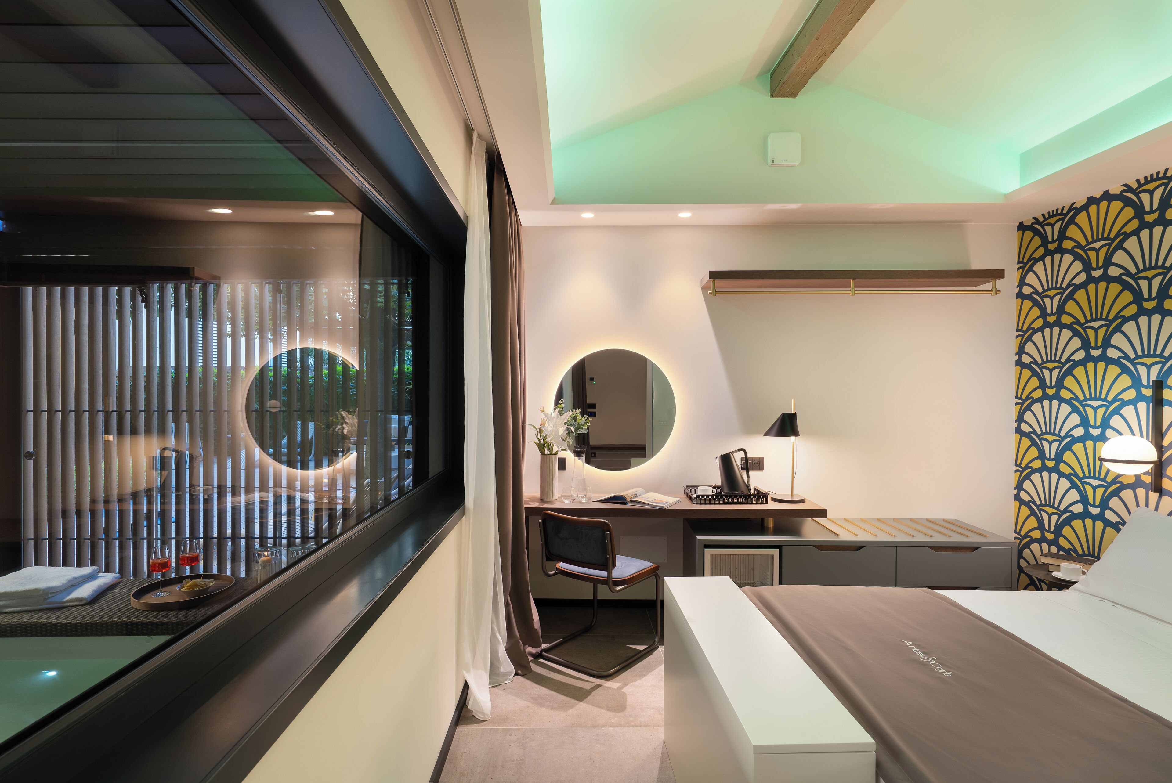 A modern hotel room with a desk, chair, and bed.