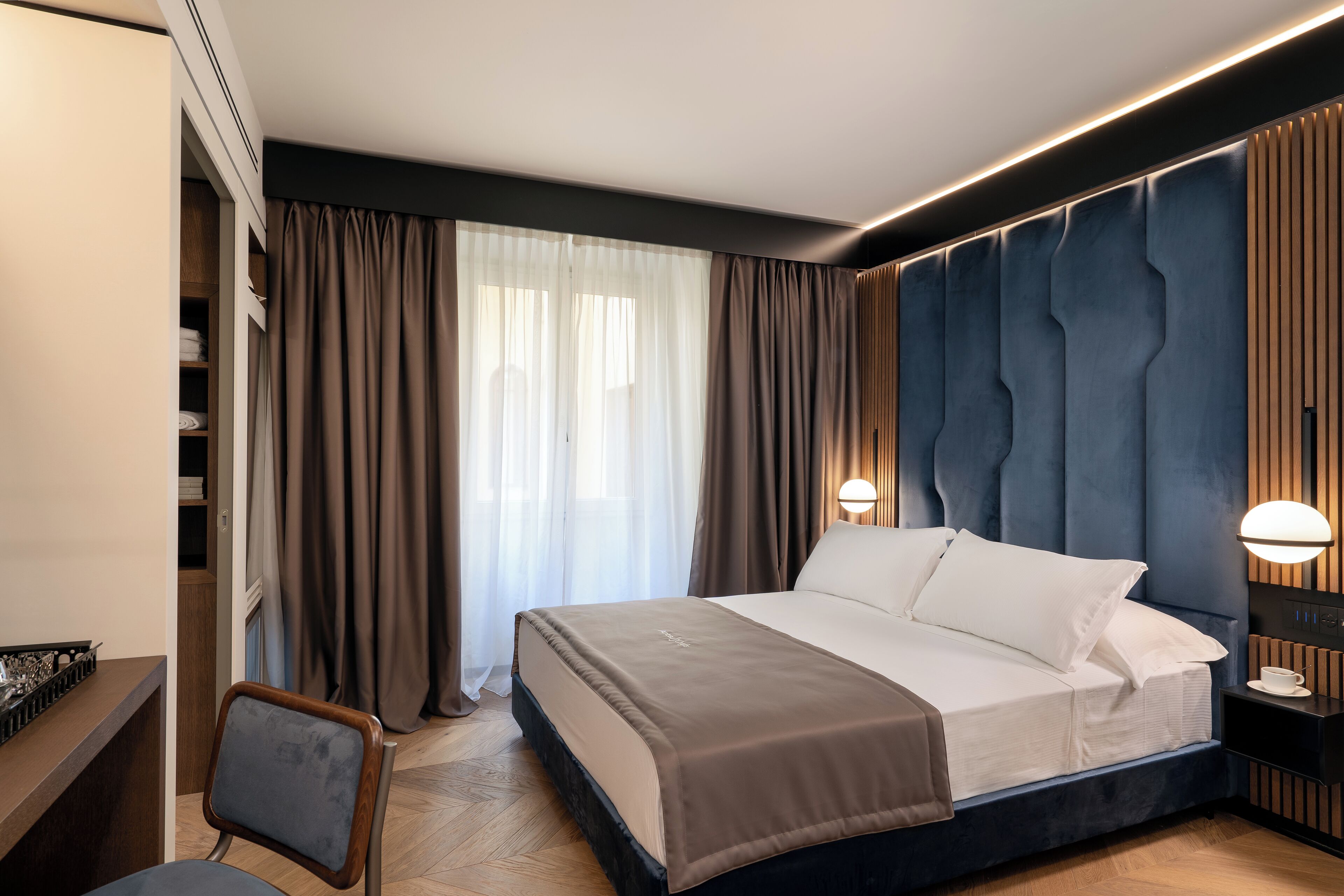 Ein modernes Hotelzimmer mit einem großen Bett, einem Schreibtisch und einem Stuhl.