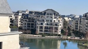Um edifício residencial com várias varandas com vista para águas calmas.