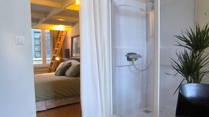 Une chambre à coucher avec un lit, une douche et une plante en pot.