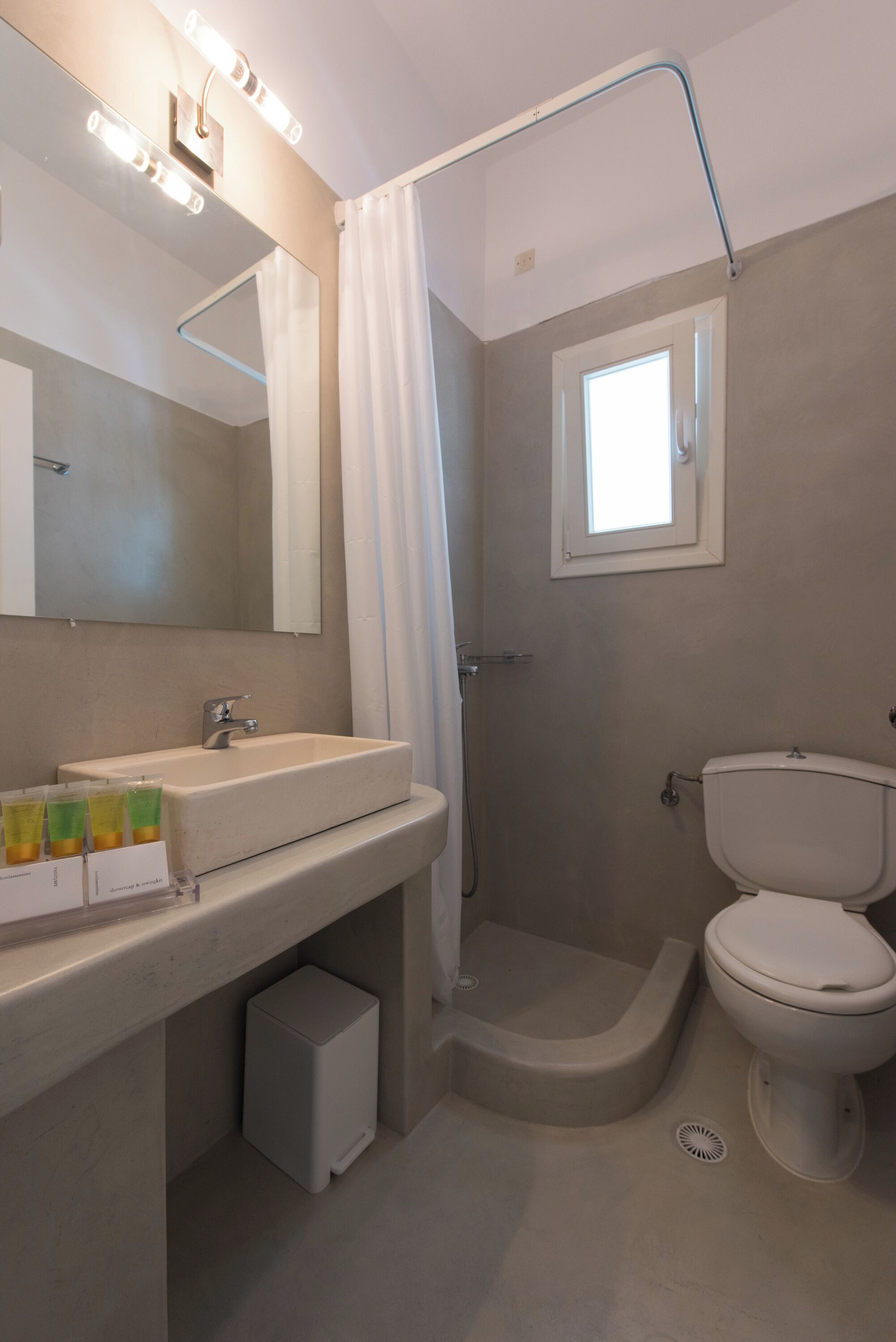 Ein Badezimmer mit Waschbecken, Spiegel, Dusche und Toilette.
