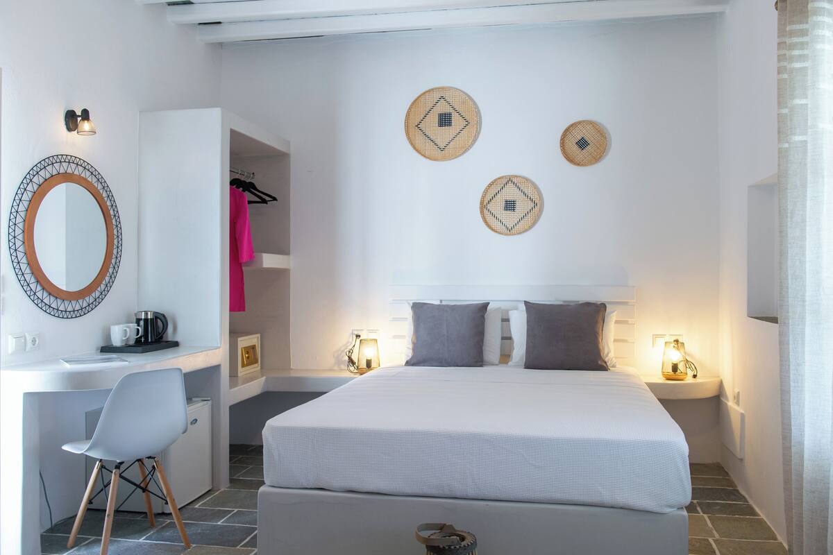 Une chambre à coucher moderne avec un lit, des tables de chevet, un bureau et une chaise.