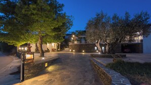 Un vialetto in pietra conduce a un edificio con un muro di pietra e un cartello.
