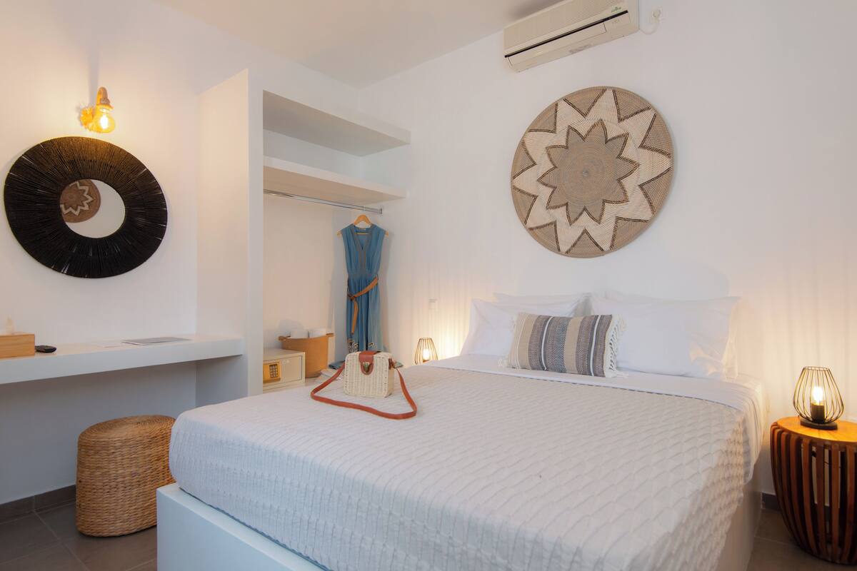 Une chambre à coucher comprenant un lit, des tables de chevet, une lampe suspendue et des éléments décoratifs sur les murs.