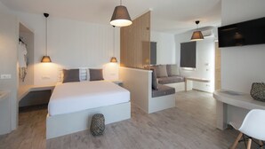 Una moderna camera d'albergo con un letto grande, una scrivania, un divano e una televisione.