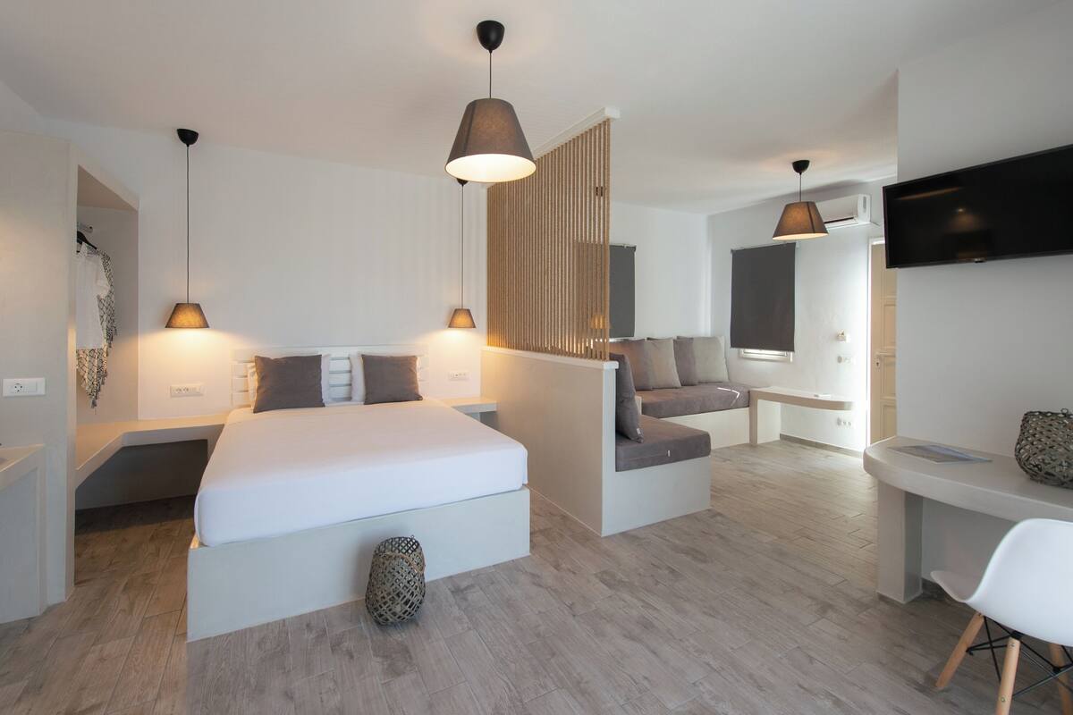 Une chambre d’hôtel moderne équipée d’un grand lit, d’un bureau, d’un canapé et d’une télévision.
