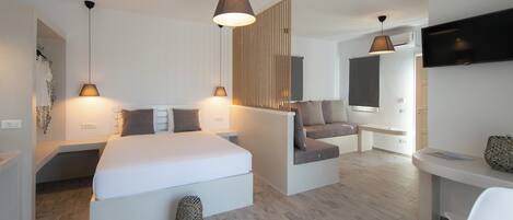 Een moderne hotelkamer met een groot bed, een bureau, een bank en een televisie.