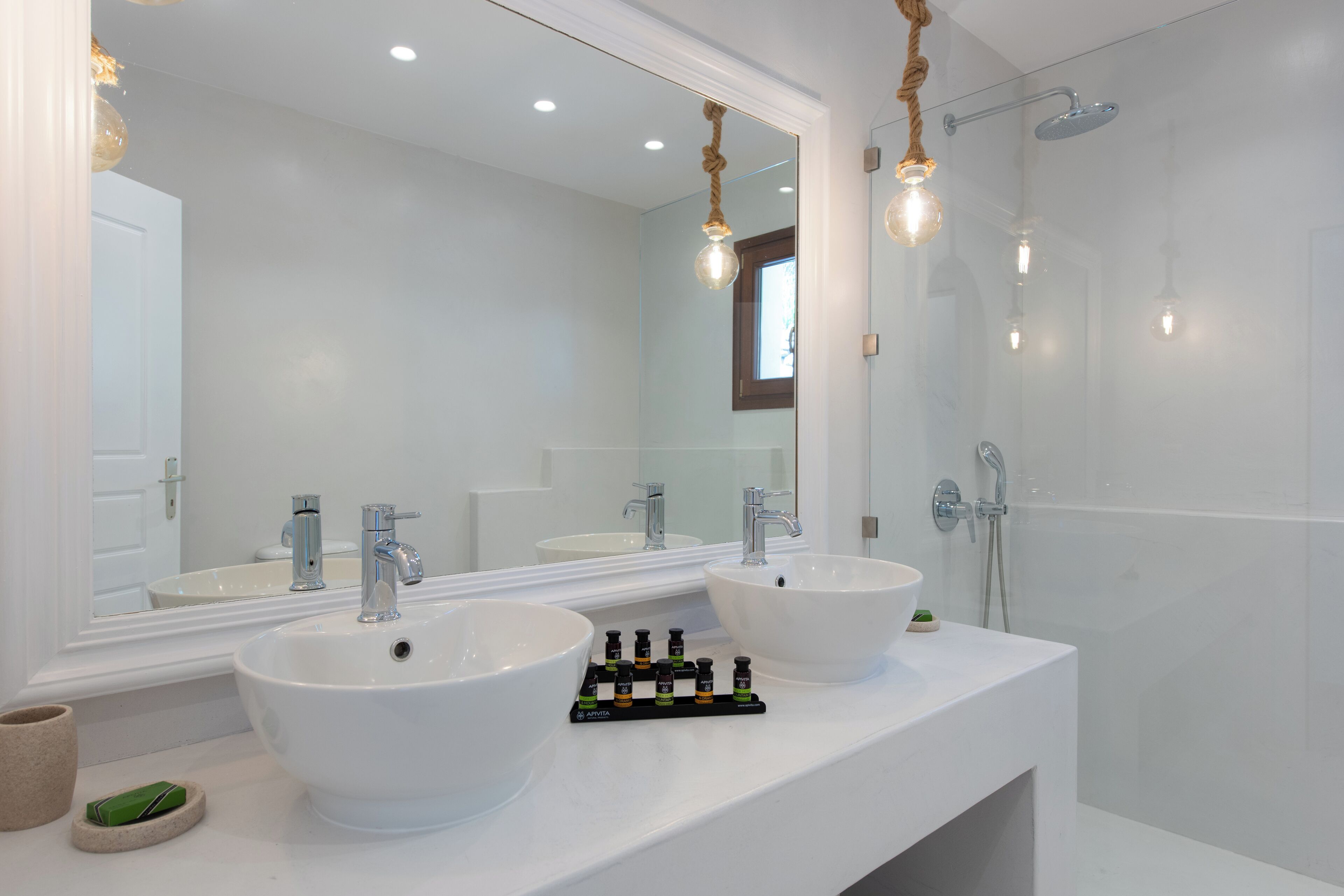 Ein Badezimmer mit zwei Waschbecken, einem großen Spiegel und einer Dusche.