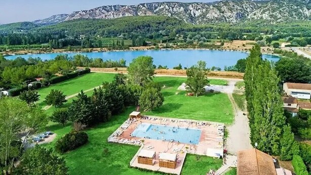 Un resort con piscina, césped verde y vistas a las montañas.