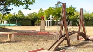 Un patio de juegos con columpios y un banco.