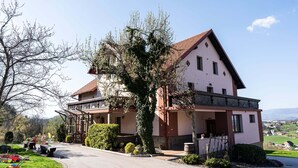 Une maison à deux étages avec un balcon, une allée et une vue sur la campagne.