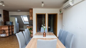 Une cuisine moderne avec une table en bois, des chaises et un vase de fleurs.
