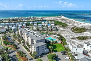 An aerial view of a coastal hotel with multiple buildings, a swimming pool, and a beach area. - Relaxing Destin Getaway Near Beaches & Attractions | Magnolia House 306 (Destin)