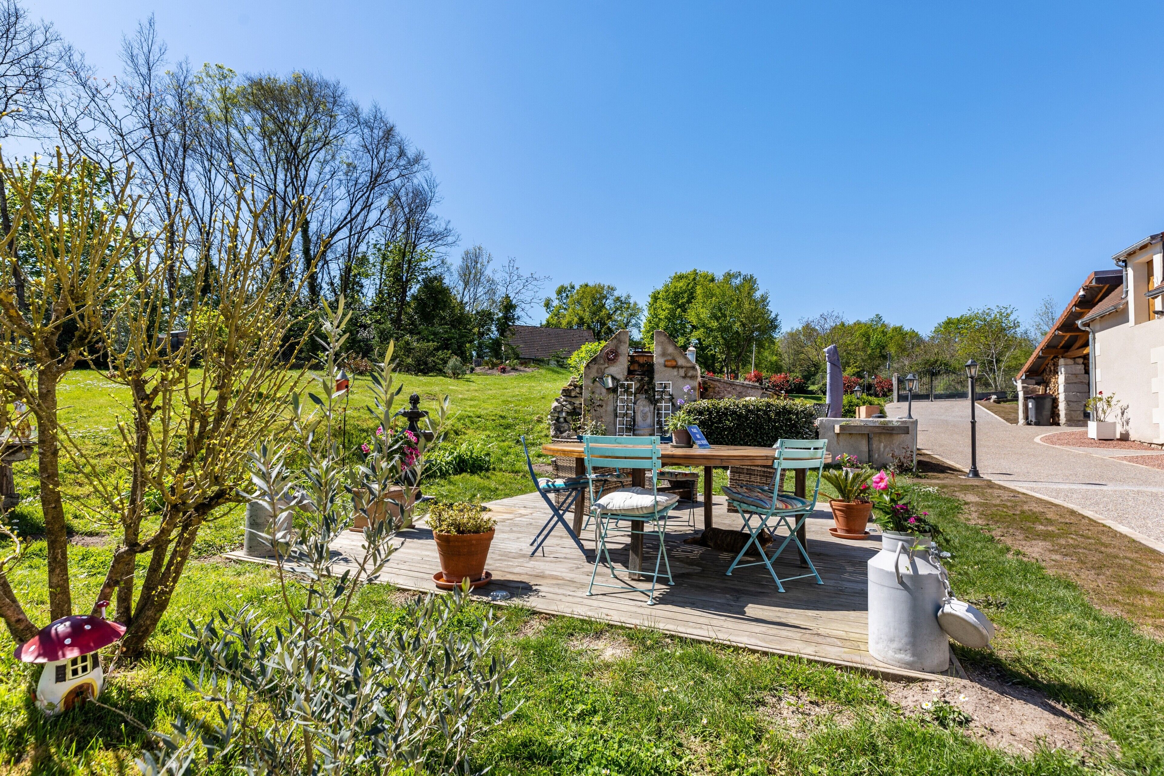 A patio with outdoor furniture, a stone table, and potted plants.