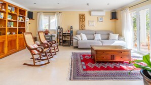 A living room with a sofa, rocking chairs, a coffee table, and a bookshelf. - Aimima - with private swimming pool (Palma)