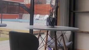 Een modern interieur met een groot raam, een ronde tafel en een zwarte stoel.