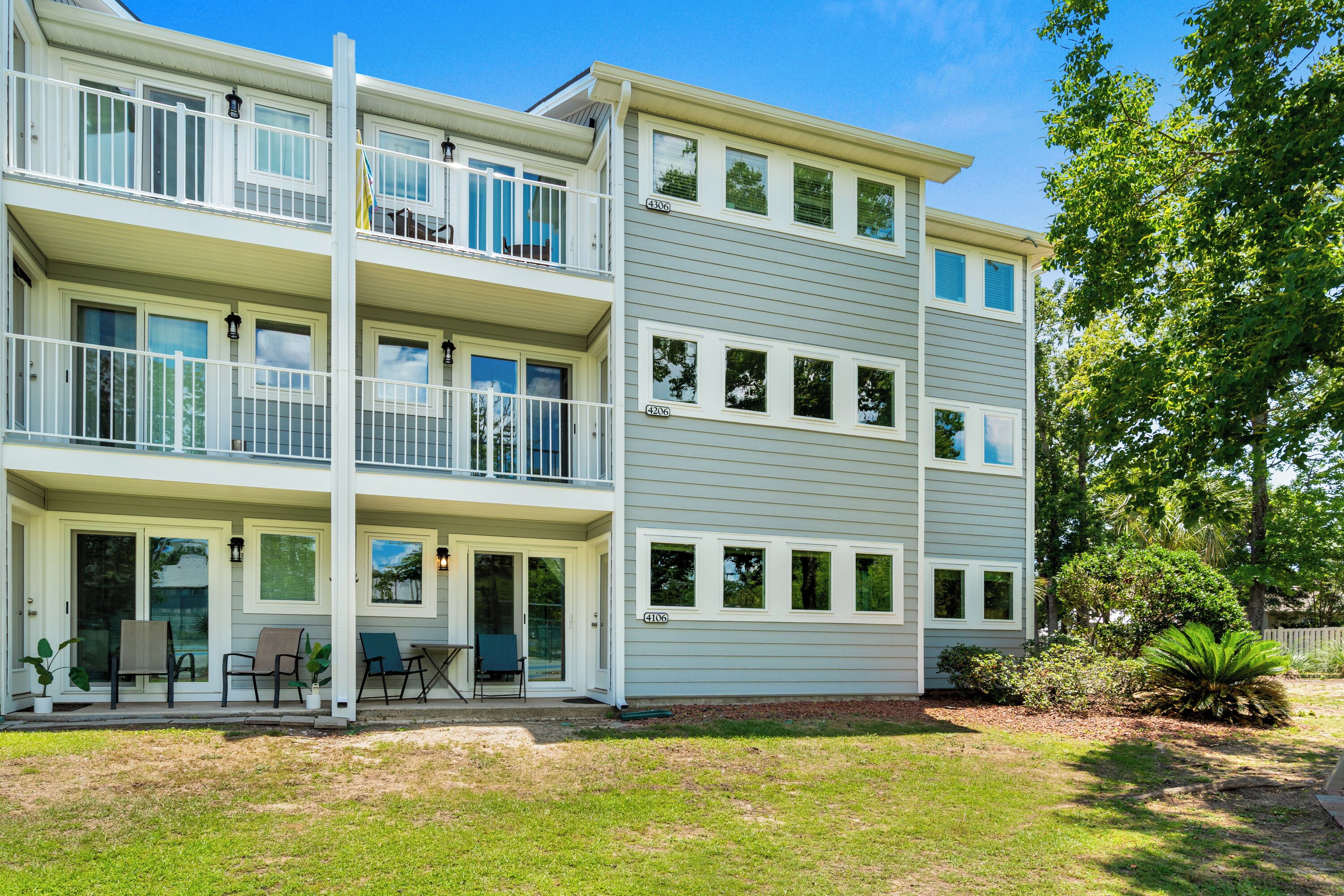A multi-story residential building with a covered front porch, multiple windows, and a well-maintained lawn.