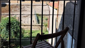 A balcony with a wooden chair, overlooking a residential area with terracotta-tiled roofs and buildings. - Cozy apartment in Acquapendente for exploring Tuscia and Tuscany. (Acquapendente)