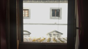 A view through a window with a door, featuring a building with a classical architectural style, including a pediment and columns. - Cozy apartment in Acquapendente for exploring Tuscia and Tuscany. (Acquapendente)