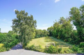A paved pathway leading to a grassy area with a soccer goal. - Spa Home With Swimming Pool, Hottub, and Sauna (Sheffield)