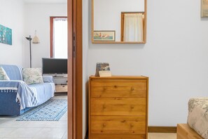 Una camera da letto con un letto, una cassettiera, una televisione e una finestra.