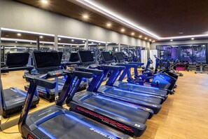A gym with multiple treadmills, exercise bikes, and weights. - The X Belek (Serik)
