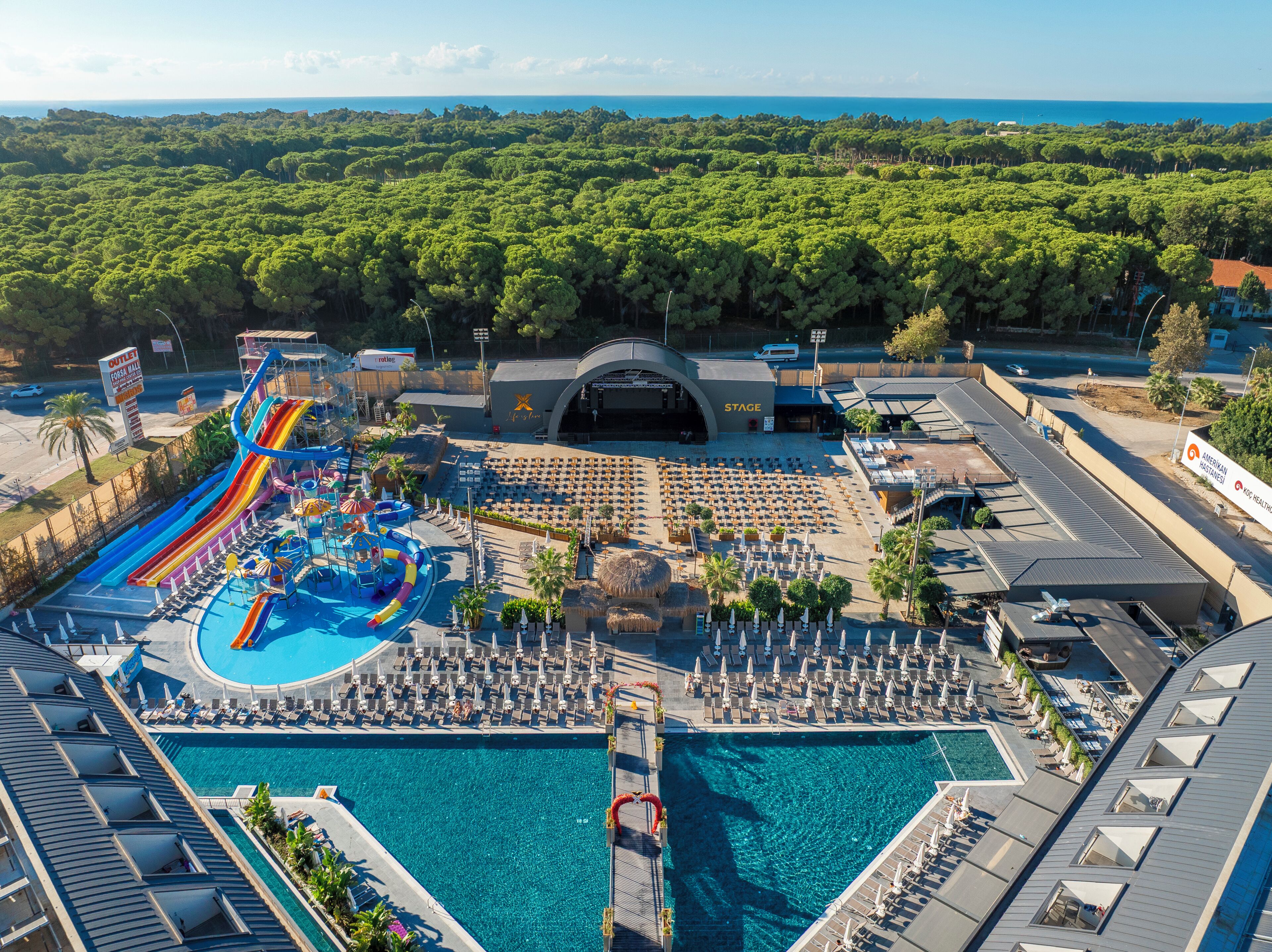A resort with a swimming pool, a water park, and a stage area.