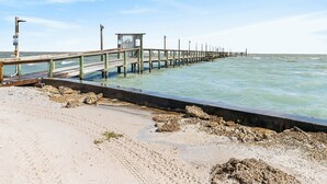 Une jetée s’avançant dans la mer, avec une petite construction à son extrémité.