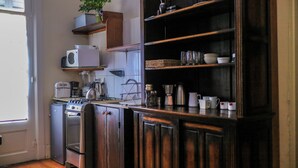 Une cuisine dotée de meubles en bois, d’un four à micro-ondes, d’une machine à café et de divers ustensiles de cuisine.