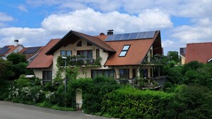 Un edificio residenziale con pannelli solari, un tetto spiovente e un balcone.