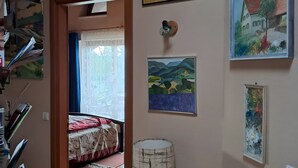 Una stanza con un letto, una lampada e diverse pitture alle pareti.