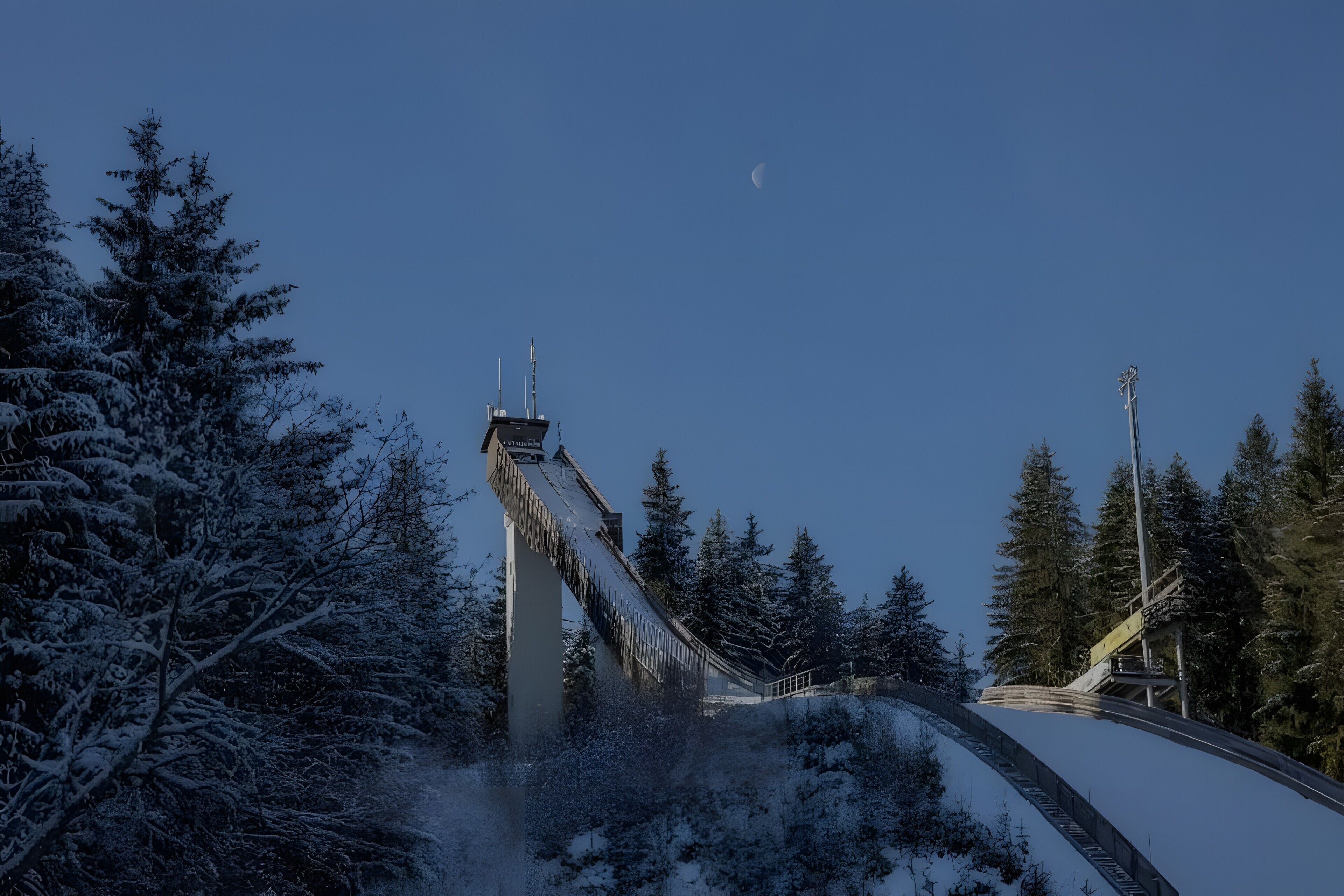 Eine schneebedeckte Brücke mit Metallkonstruktion und blauem Himmel.