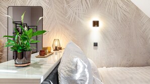 A modern bedroom with a large mirror, a potted plant, a bedside table, and a textured ceiling. - The Summit Rooftop Spa Meissen – Exclusive Penthouse with Jacuzzi & Sauna (Meißen)