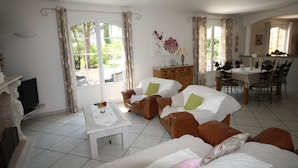 A cozy living room with a sofa set, a dining table, and a TV. - Bastide Carpe Diem (Fabrègues)