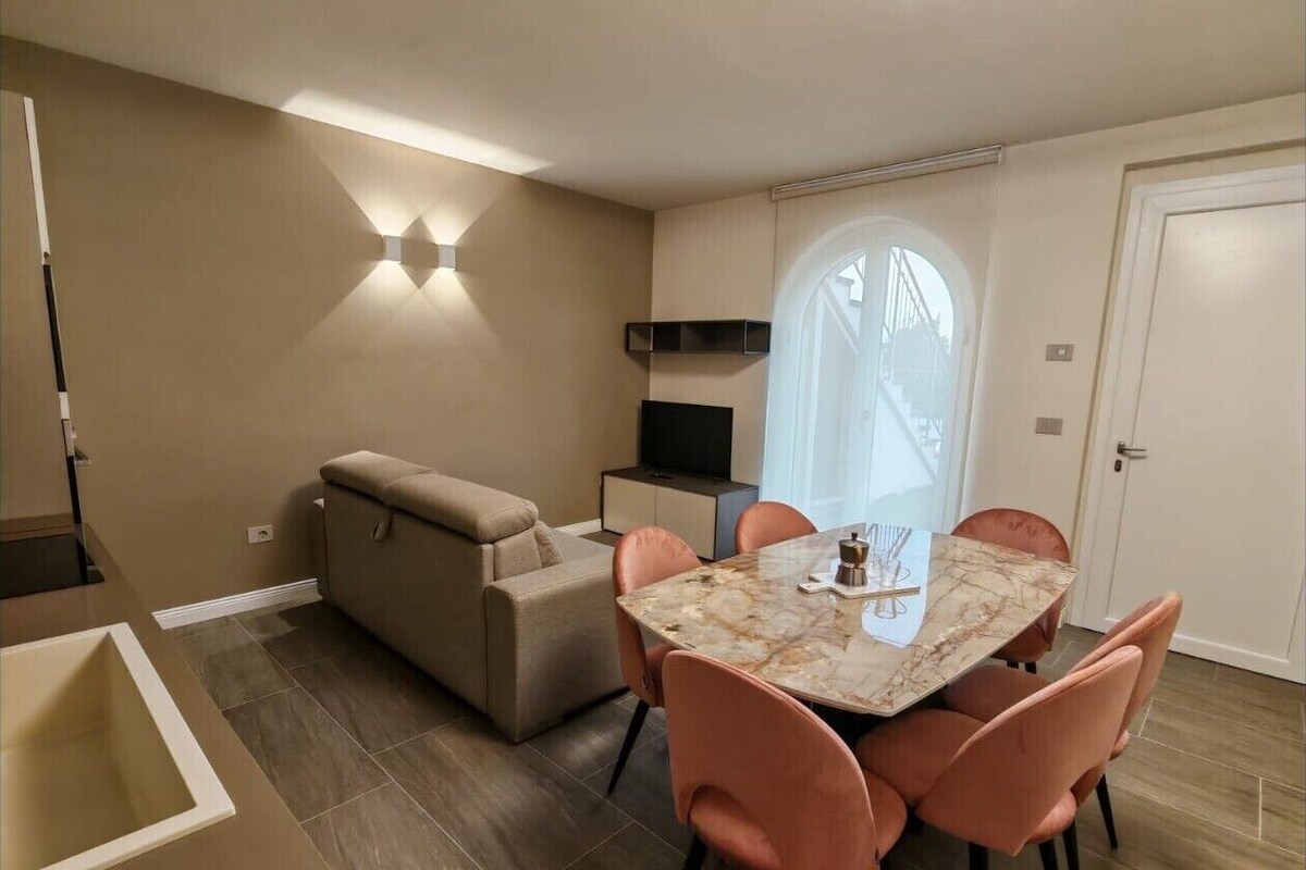 Un espace de vie compact comprenant un coin repas, un canapé, un téléviseur et une fenêtre donnant sur un beau paysage.