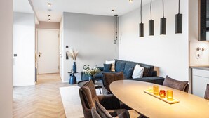 A modern interior with a dining area, sofa, and kitchen. - The Summit Suite I Meissen – Luxury Penthouse with Elbe and Cathedral Views (Meißen)