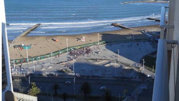 Eine Küstenansicht mit Strand, Promenade und Ozean.