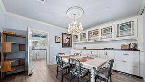 A spacious kitchen with white cabinetry, a dining table with chairs, and a chandelier. - Stunning Views Gated Mountain Retreat 20 Acres (Garland County)