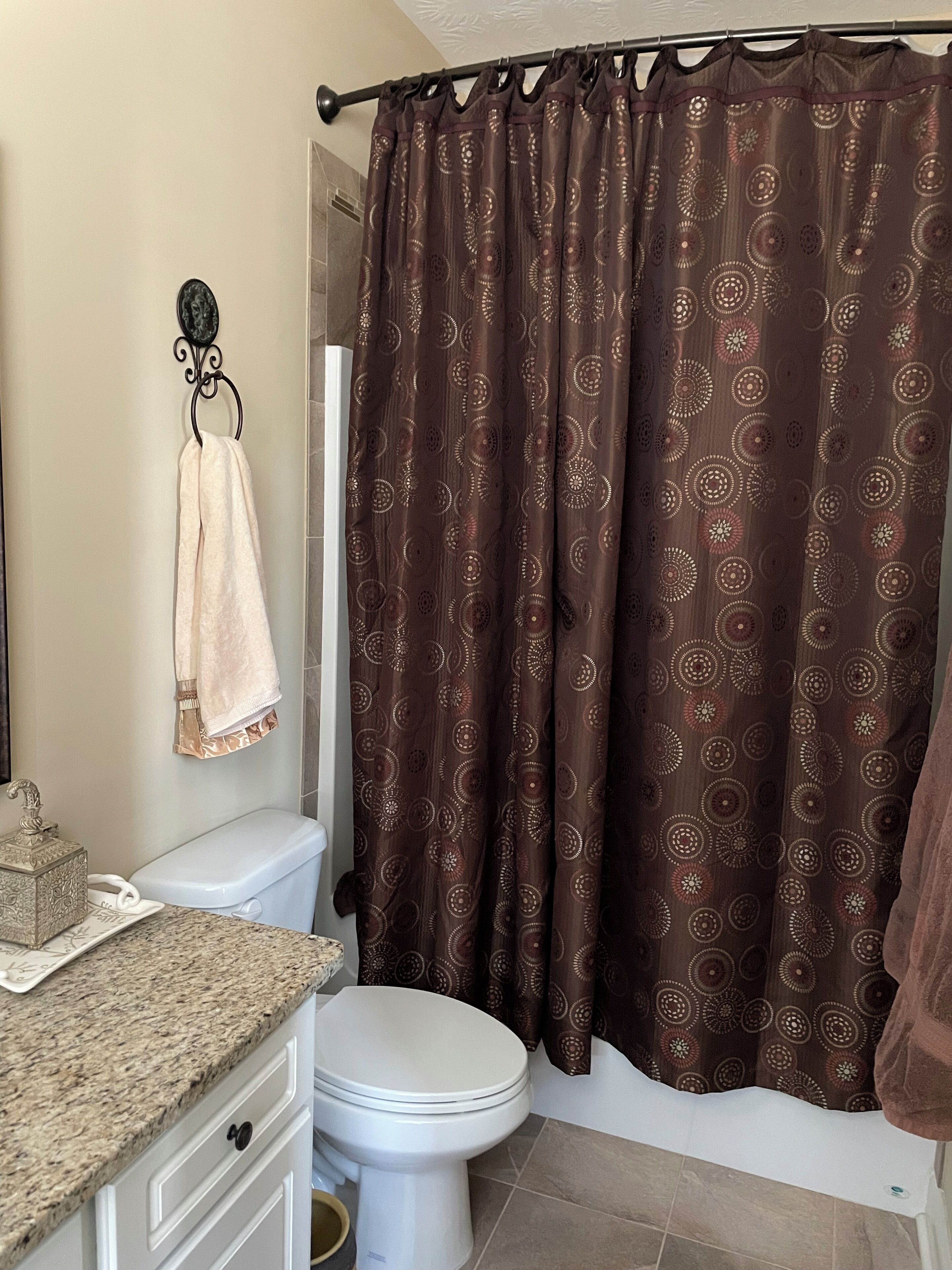 A bathroom with a toilet, sink, and shower curtain.