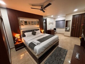 Una camera da letto moderna con un letto grande, lampade sui comodini, una ventola a soffitto e opere d'arte alle pareti.