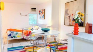 Una sala moderna con un sofá, una mesa redonda y una alfombra colorida.