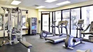 A gym with treadmills, elliptical machines, and weightlifting equipment. - @ Marbella Lane Chic Seaside Studio w/ Pool View (Honolulu)
