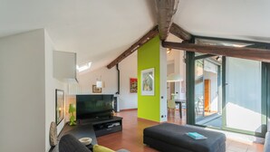 A modern living room with a flat-screen TV, comfortable seating, and a bright green accent wall.