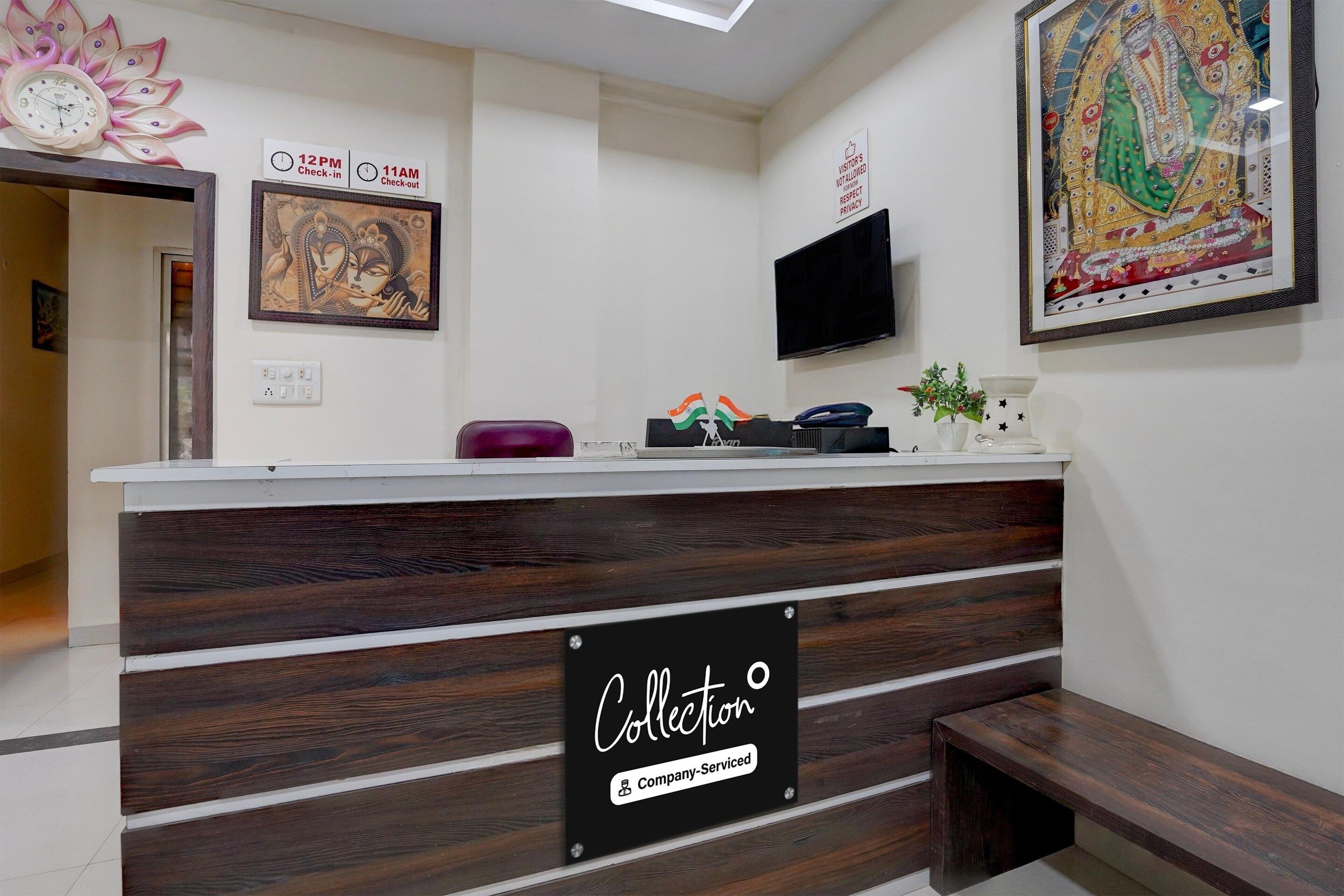 A reception desk with a 'Collection' sign, a clock, and artwork on the walls.
