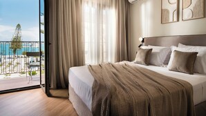 Ein modernes Hotelzimmer mit einem großen Bett, einem Balkon mit Meerblick und einer Klimaanlage an der Wand.