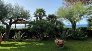Ein gepflegter Garten mit unterschiedlichen Pflanzen und einem Pavillon.