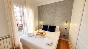 Une chambre d’hôtel avec un grand lit, une vue sur la ville et un mur décoré de motifs.