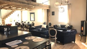 Un intérieur moderne comprenant un coin repas, des canapés et une cheminée.